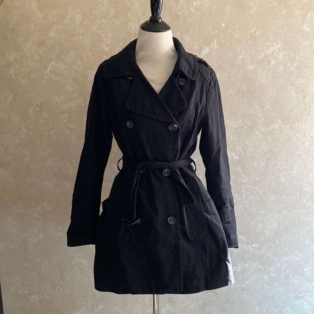 Black trench coat. Hits mid thigh. Lined and multiple pockets and extra buttons